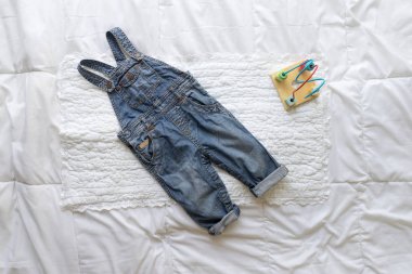 Beyaz arka plan üzerinde oyuncaklarla bebek giysileri