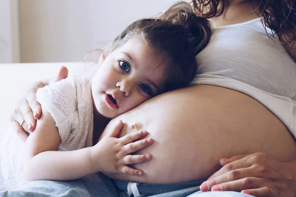 Glückliches Mädchen umarmt Schwangeren den Bauch — Stockfoto