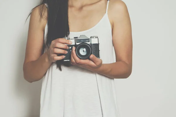 Woman holding a vintage camera front a white background — Stock Photo, Image