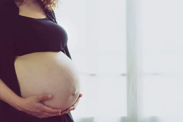 Terhes nő áll szemben az ablakkal — Stock Fotó