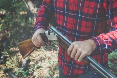 Ormanda silahlı bir avcı.