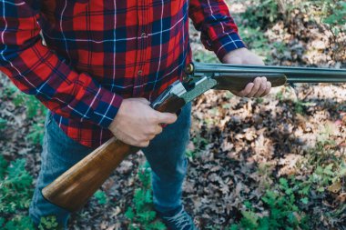 Ormanda silahlı bir avcı.