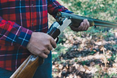 Ormanda silahlı bir avcı.