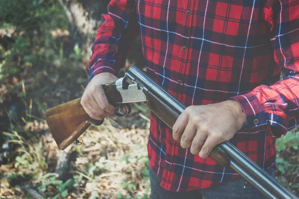 Ormanda silahlı bir avcı.