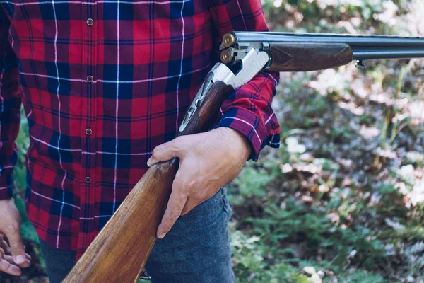 Ormanda silahlı bir avcı.