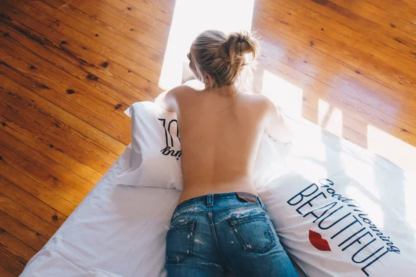 Жінка без сорочки лежить на ліжку вдома — стокове фото