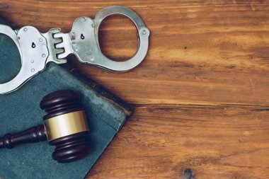 Tokmak, hukuk kitapları ve kelepçe ahşap arka plan üzerinde hakim