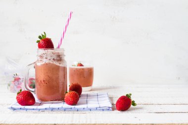 çilek ve üzüm berry yüzlü beyaz ahşap tahta üzerinde bir kavanoz