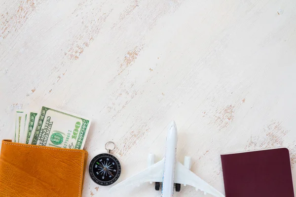 旅行の概念 白い木製の背景にコンパスのパスポートと航空機グッズ付きレザー ウォレットの旅行のためのお金 — ストック写真