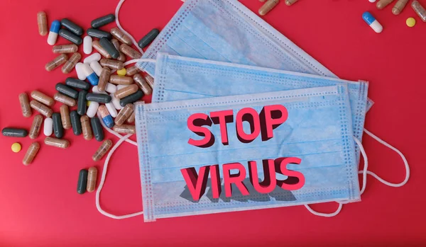 ウイルスを止めるという言葉の薬や医療用マスクの束 — ストック写真