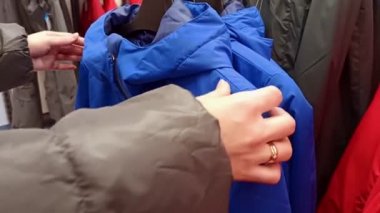 Mağazadaki mavi cekete bakan bir kadın.
