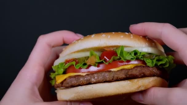 Una mujer está sosteniendo una hamburguesa grande en primera persona — Vídeo de stock