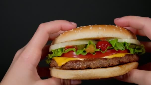 A woman is holding a large Burger in the first person — Stock video