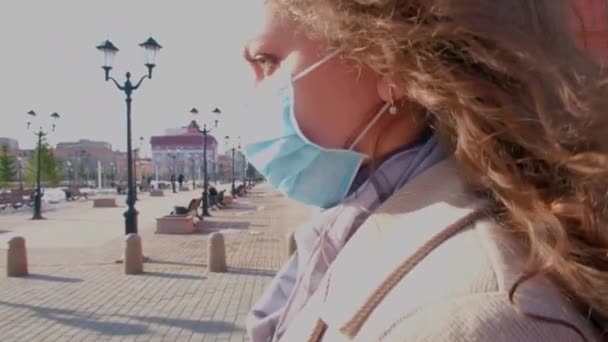 Curly girl in a medical mask goes slow motion — Stock Video