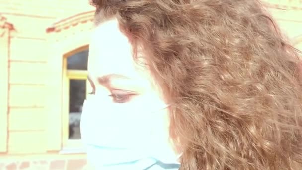 Curly girl in a medical mask goes slow motion — Stock Video