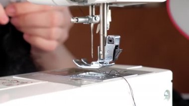 Hareket halindeki dikiş makinesi için iğne. Dikiş makinesinin iğnesinin yakın çekimi hızla yukarı ve aşağı hareket eder.