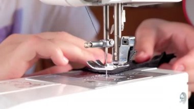 Terzi siyah dantel bir kumaş dikmiş.