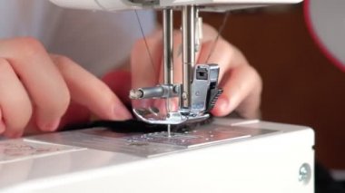 Terzi siyah dantel bir kumaş dikmiş.