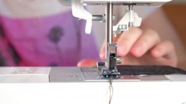 Terzi siyah dantel bir kumaş dikmiş.