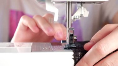 Terzi siyah dantel bir kumaş dikmiş.