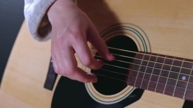 Cüppeli kız gitar çalıyor.