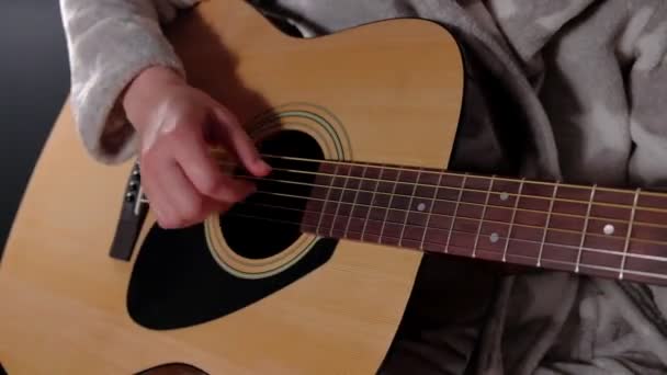 Het meisje in de badjas speelt gitaar. — Stockvideo
