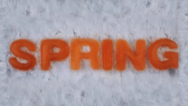 Letters made of ice melt in snow, timelapse. Background. Concept end of winter and beginning of spring. Cold weather gives way to warm weather. Holidays and celebrations. Christmas and New years eve — Stock Video