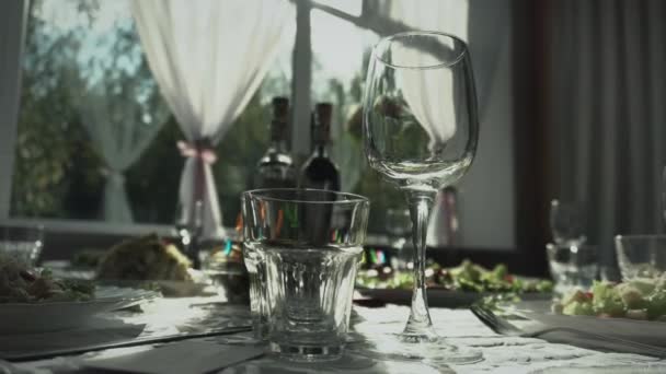 Catering. Empty wine glass with alcoholic drinks is on the table. Banquet about solemn event. Background. Plates with appetizers and salads. Holiday. Handheld shooting — Stock Video