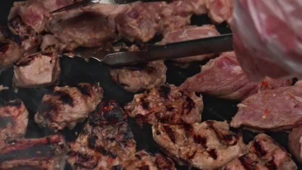 スローモーションで屋外で火をつけてバーベキューグリルで豚肉の牛肉肉のフライドポテト部分を調理します。食べ物とケータリング。伝統的な伝統的なマリネ料理Shashlikまたは魚のケバブはバーベキューで揚げられます。閉じろ! — ストック動画
