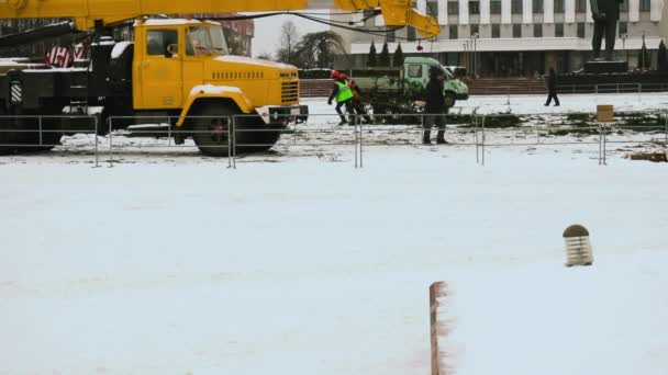 労働者は正月やお祝いの後に市の中央広場にクリスマスツリー構造を分解します。第2部。冬の航空作業プラットフォーム。手を広げて. — ストック動画