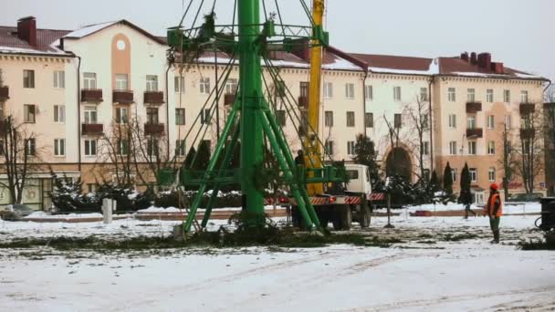 I lavoratori smontano una struttura di albero di Natale nella piazza centrale principale della città dopo le vacanze e le celebrazioni di Capodanno. Parte 6. Piattaforma aerea di lavoro in inverno. Mano tenuta a metà tiro — Video Stock