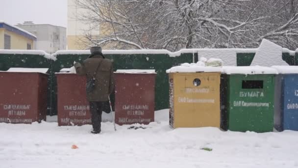 Pensionista joga lixo em latas de lixo de rua no inverno, câmera lenta BOBRUISK, BELARUS - JANEIRO 14, 2019 — Vídeo de Stock