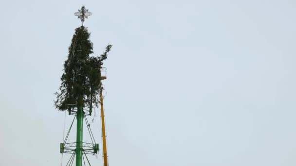 Munkások szétszerelni egy karácsonyfa szerkezetét a főtéren a város után az újévi ünnepek és ünnepségek. 5. rész. Légi munka platform télen. Kézzel tartott közepén lövés — Stock videók