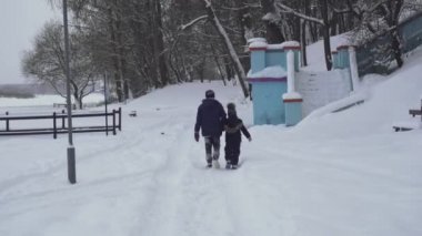 Büyük ve küçük kardeşler ya da arkadaşlar kışın karda el ele yürürler. Çocukluktan beri dostuz. Çocuklar gündüz vakti yan yana seyircilere gider..