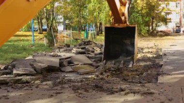 Bir kazıcının arka kovası bir apartmanın avlusunu kazıyor. Gaz ve su temini, eski boruları değiştirmek, kaza.