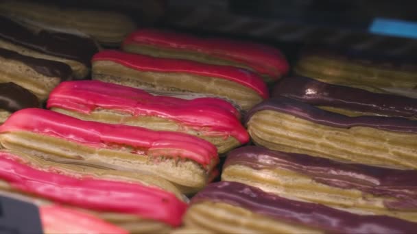 Zestaw świeżo upieczonych eklerek słodycze mąka słodycze słodycze leżą w sklepie sklepowym. Desery i bagietki. Produkty piekarnicze w sklepie. Ruch kamery ciężarówki ze zjeżdżalnią — Wideo stockowe