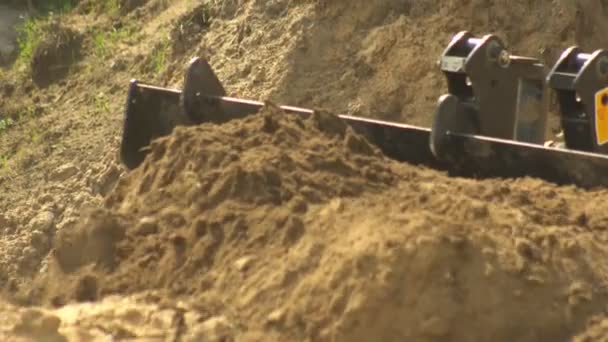 Tractor loader picking up soil in a large bucket during the construction of the road, background, industry, 4K, multifunctional — Stock Video