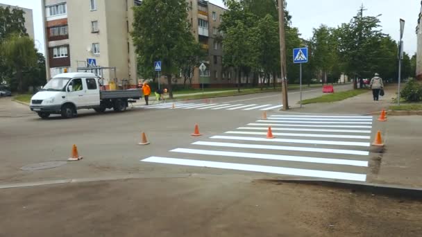 Los trabajadores aplican pintando cebra horizontal para cruzar peatones en encrucijadas de asfalto urbano — Vídeo de stock