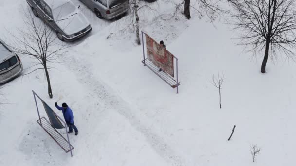 Dos hombres extraen y limpian alfombras para el hogar en invierno . — Vídeos de Stock