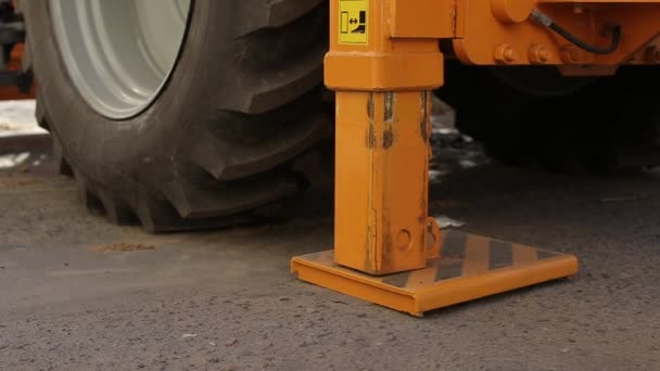 Pliage de l'arrêt hydraulique dans la pelle du tracteur après achèvement des travaux, gros plan — Video