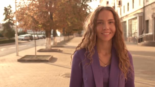 Jong meisje met krullend haar en bruine huid toont een klasse gebaar op een stad-achtergrond, kopieer ruimte, slow motion — Stockvideo