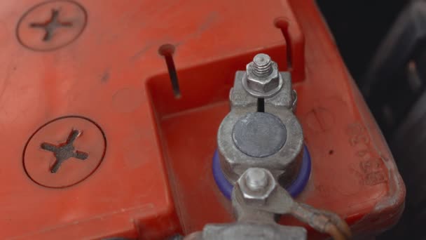 On connecte le câble de serrage négatif noir au bornier de la batterie automobile. Capot ou capot soulevé en hiver de jour dans le stationnement de la cour. Dysfonctionnement ou problème avec l'auto. Gros plan. Partie 4 — Video