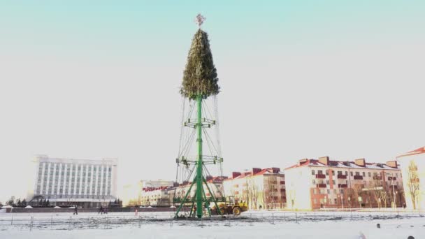 Desmontar o montar la construcción del árbol de Navidad en la plaza principal de la ciudad. El concepto final. Vacaciones y celebraciones de Año Nuevo. Humor festivo. Mano de tiro ancho — Vídeo de stock