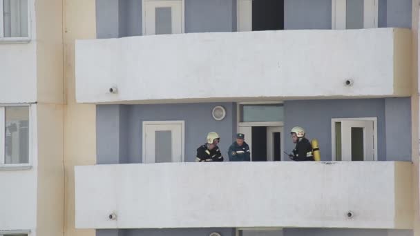 Bobruisk, Belarus - 24 Eylül 2019: Yangını söndürdükten sonra itfaiyeciler evin balkonundalar. 911 servisi, insanları kurtarmak. — Stok video