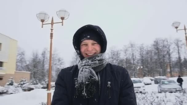 Mosolygó és boldog fickó örvénylik maga körül télen hóesésben nappal lassított felvételen. Sznorrikám vagy testre szerelhető kamera. Szórakozás és gondtalan idő. Mentesség és egészség. — Stock videók