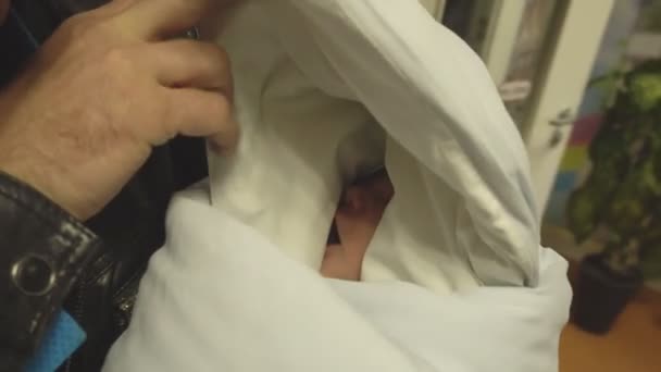 Father takes a newborn beautiful baby from the hospital home, close-up — ストック動画