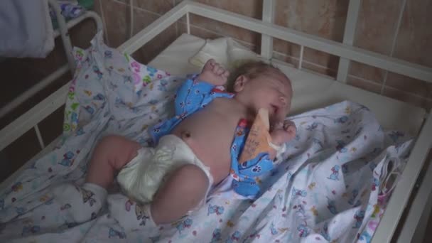 Pequeño niño caucásico bebé hermoso se encuentra en el hospital antes del alta. Hospital de maternidad, primer plano — Vídeos de Stock