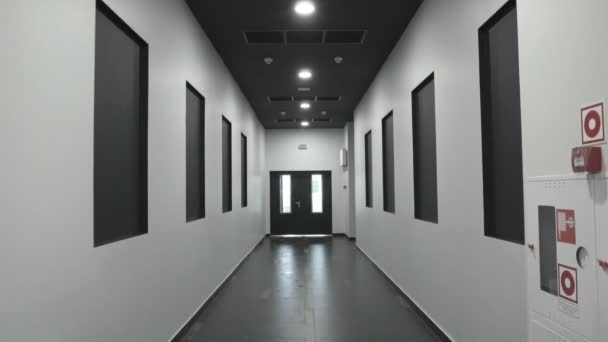L'homme descend le couloir jusqu'à la sortie dans un centre commercial, vue à la première personne. Tir à la main. Bâtiment intérieur. Évacuation incendie 