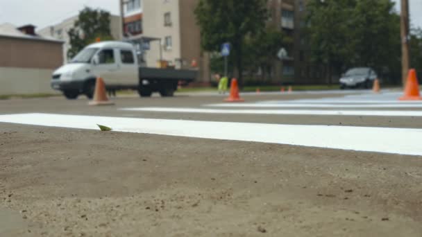 Los trabajadores aplican pintando cebra horizontal para cruzar peatones en encrucijadas de asfalto urbano — Vídeos de Stock