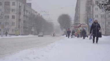 Bobruisk, Belarus - 14 Ocak 2019: İnsanlar şehirde kışın otobüs durağına gelir, kar yağışı, ağır çekim